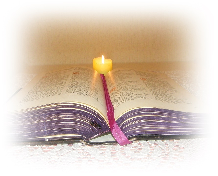 Avattu raamattu. jonka takana  palava kynttilä